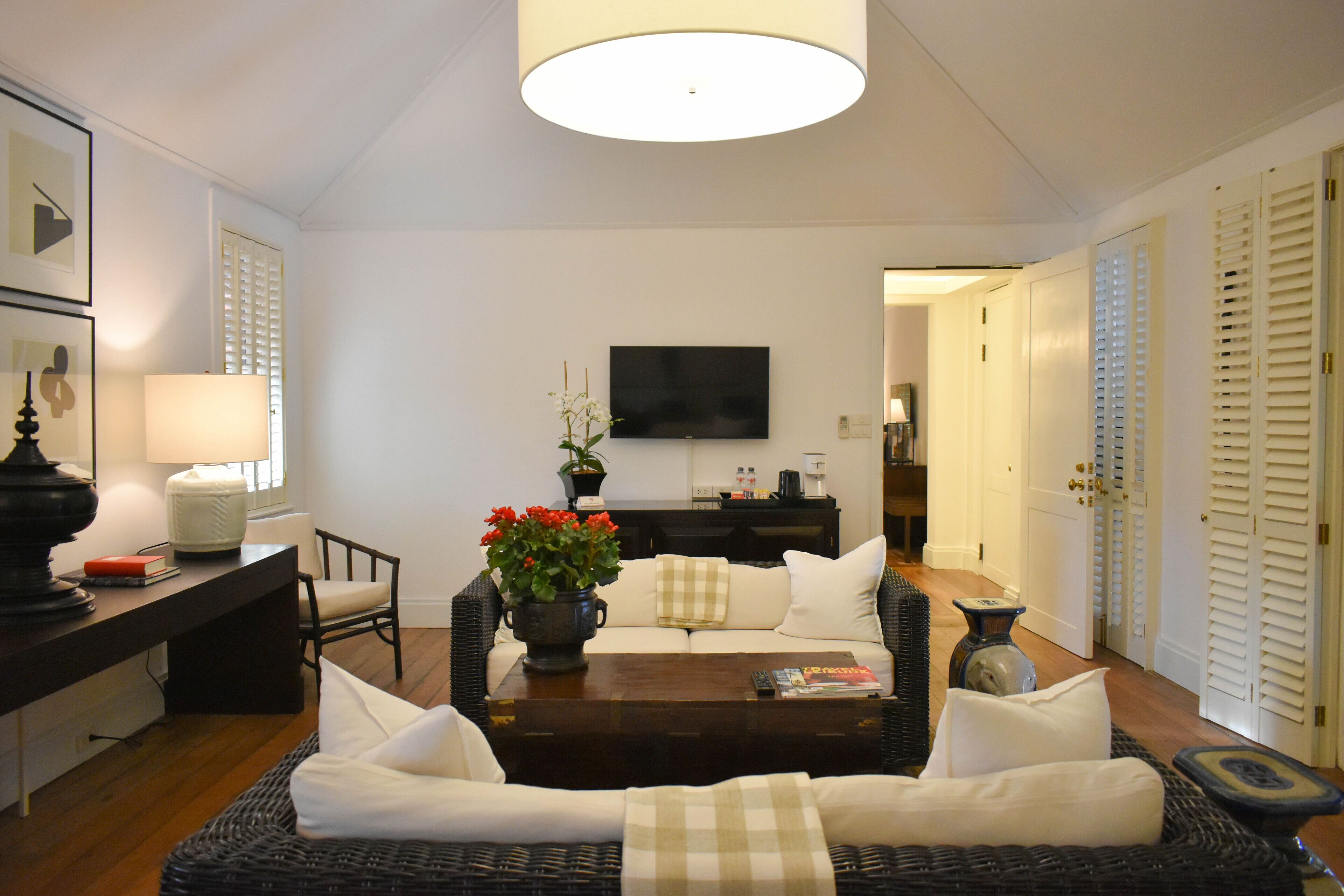 A living room with a sofa, coffee table, and a TV mounted on the wall.