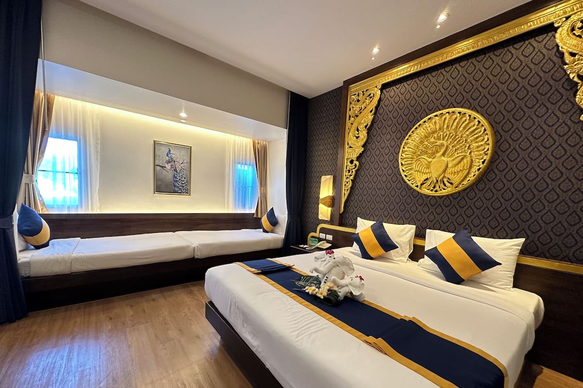 Habitación de hotel con una cama grande, zona de estar con vistas y decoración en la pared.
