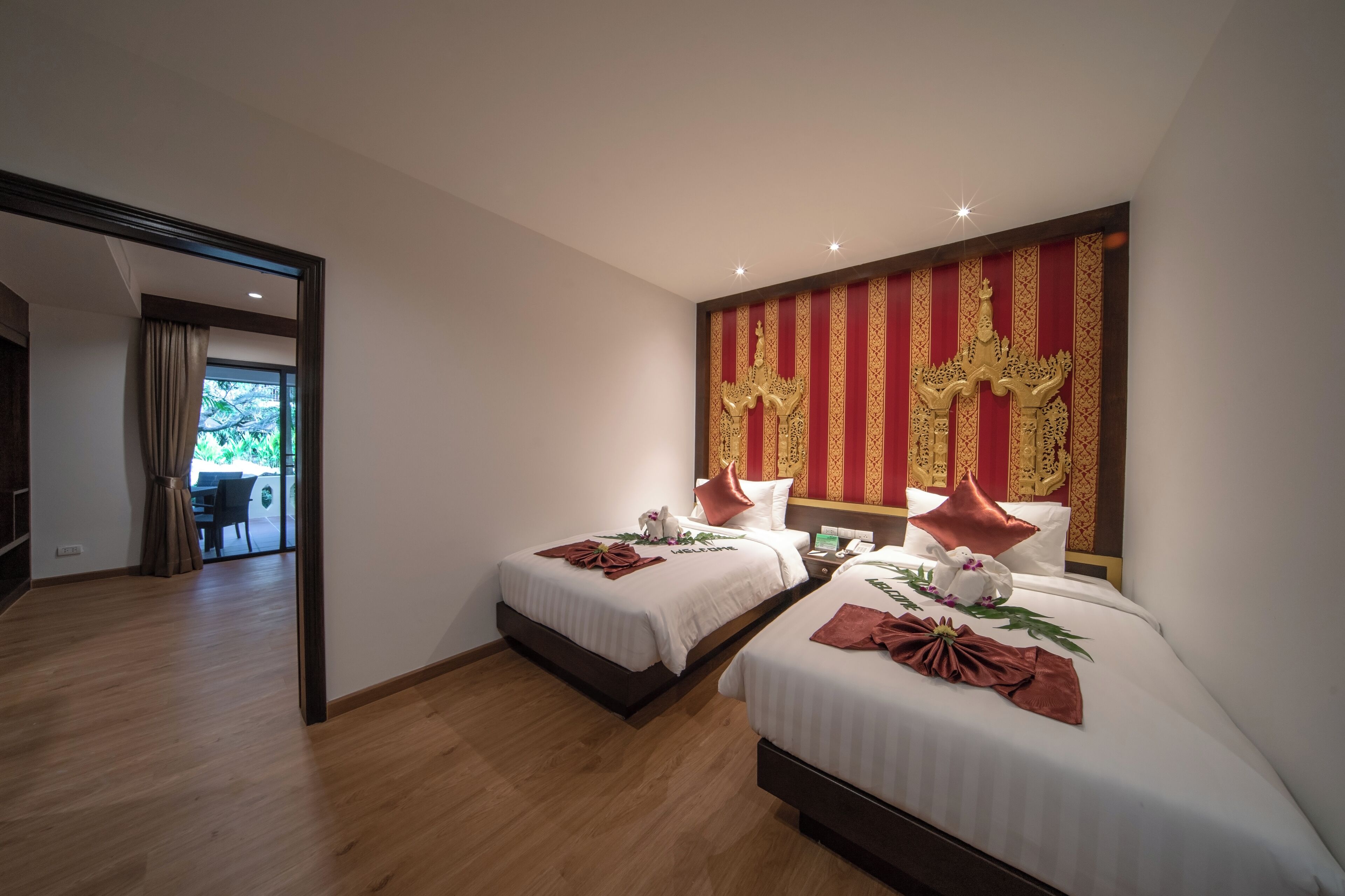 Une chambre d’hôtel avec deux lits, un grand mur décoratif et une vue sur l’extérieur.