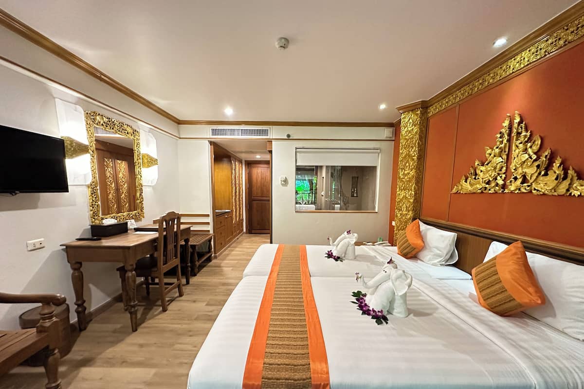 Habitación de hotel con una cama grande, un escritorio, un televisor y vistas al exterior.