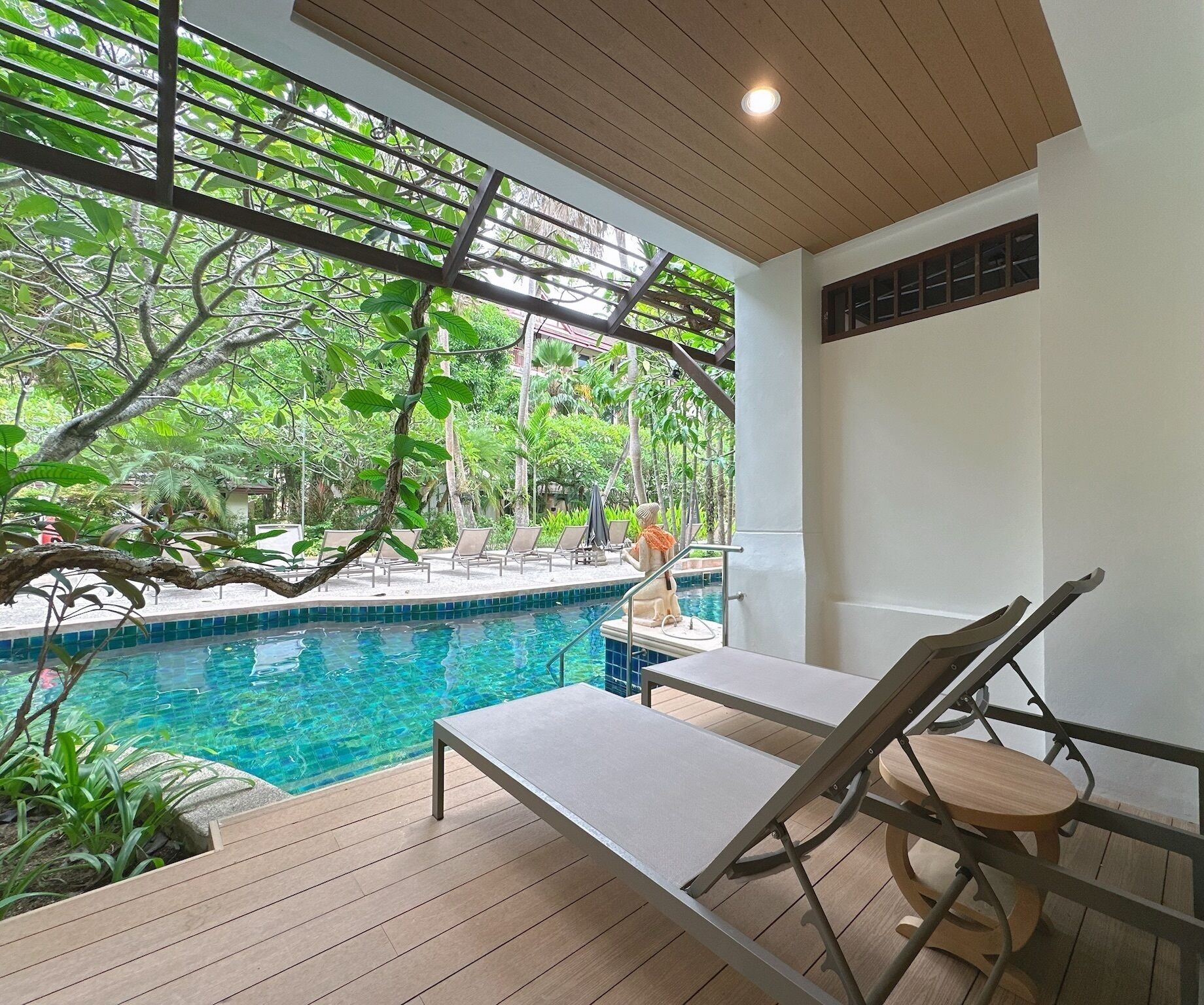 A pool area with lounge chairs and a wooden deck.