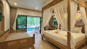 A traditional four-poster bed with a canopy, a wooden nightstand, and a desk with a chair.