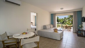 Une chambre d’hôtel comprenant un lit, une table à manger avec des chaises, un téléviseur et une vue sur l’extérieur.