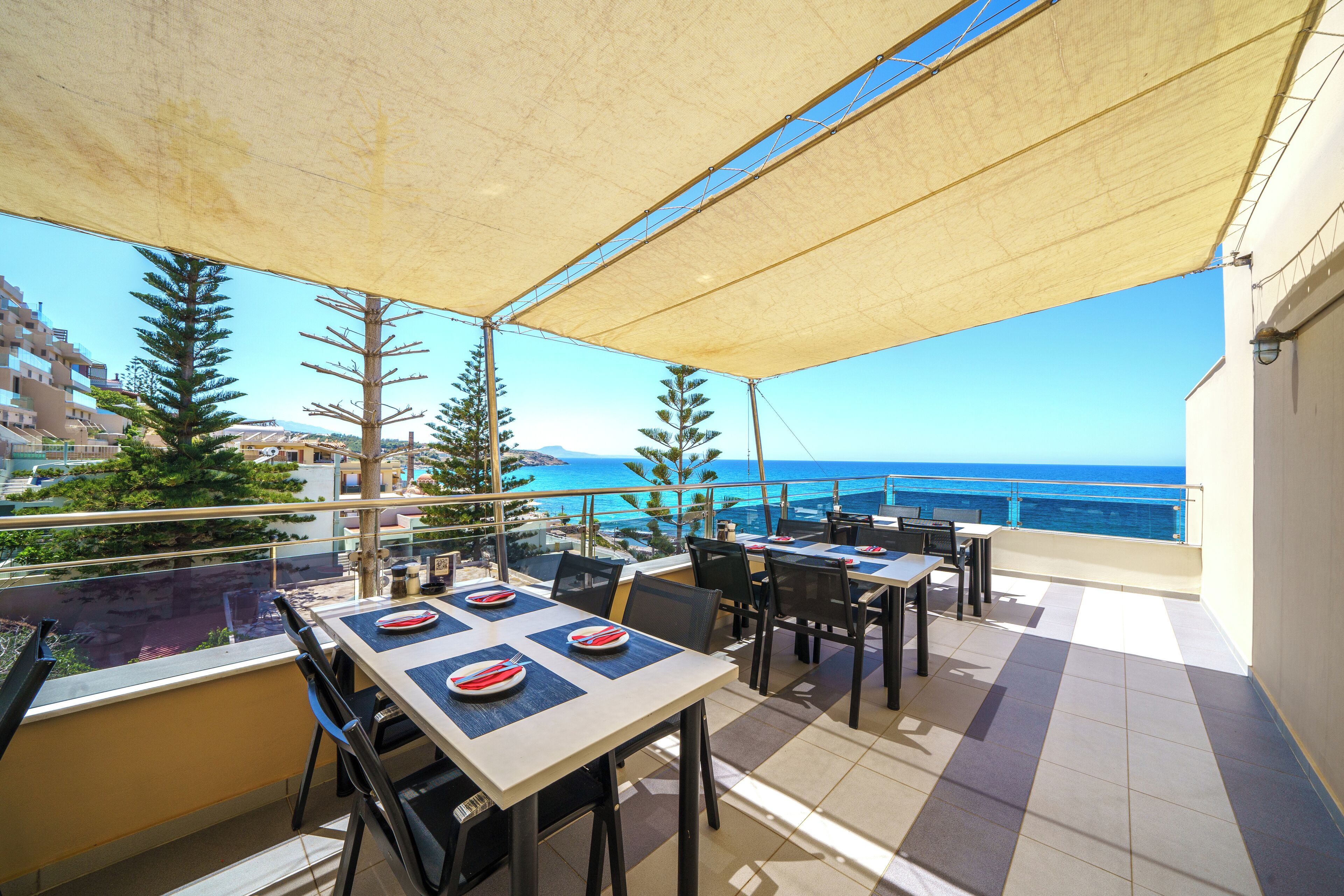 Una terraza con mesas y sillas, con vista al mar.