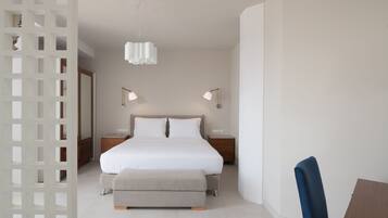 Ein modernes Schlafzimmer mit einem großen Bett, Nachttischen und einem Sessel.