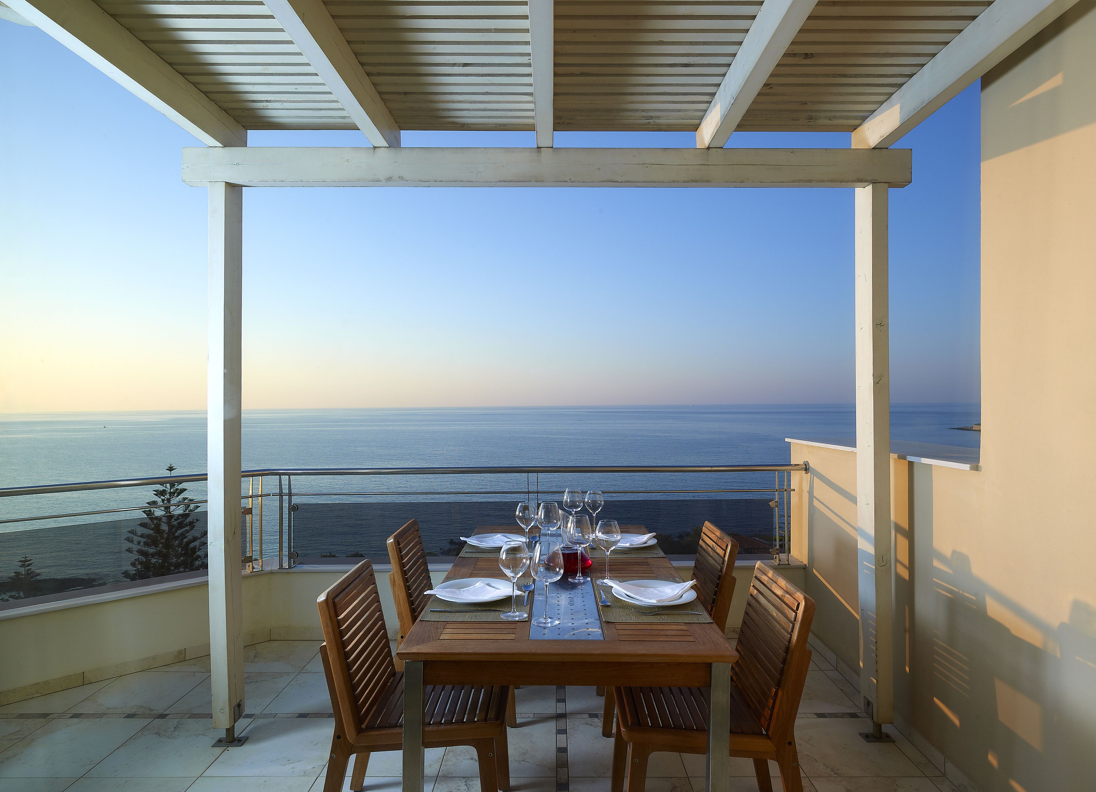 A dining table set for four with a view of the sea.