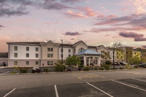 Un hôtel doté d’une cour intérieure, de nombreux espaces de stationnement et d’un bâtiment surmonté d’un toit bleu.