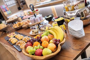 A buffet with various food items including fruits, pastries, and beverages. - Das Reinisch Hotel - near Vienna Airport (Schwechat)