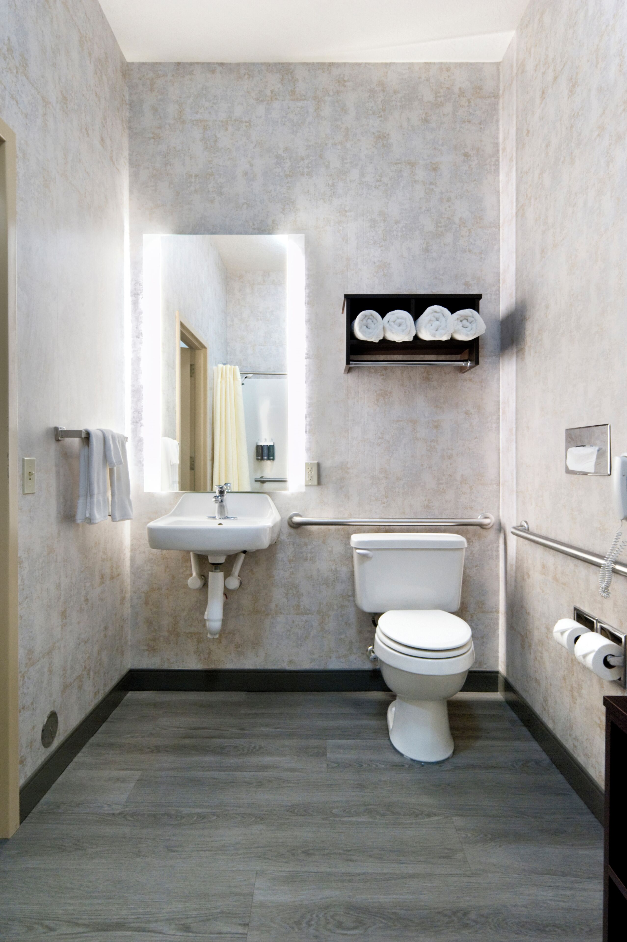 Ein Badezimmer mit einem weißen Waschbecken, einer Toilette und einem Spiegel.