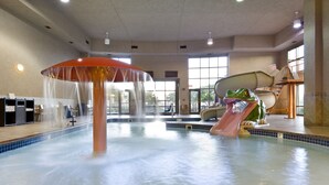 An indoor swimming pool with a water slide, a large umbrella structure, and a frog-shaped water feature. - Clubhouse Hotel Suites Sioux Falls (Sioux Falls)