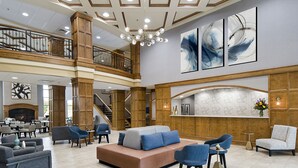 A spacious lobby with a central seating area, a staircase, and a fireplace. - Clubhouse Hotel Suites Sioux Falls (Sioux Falls)