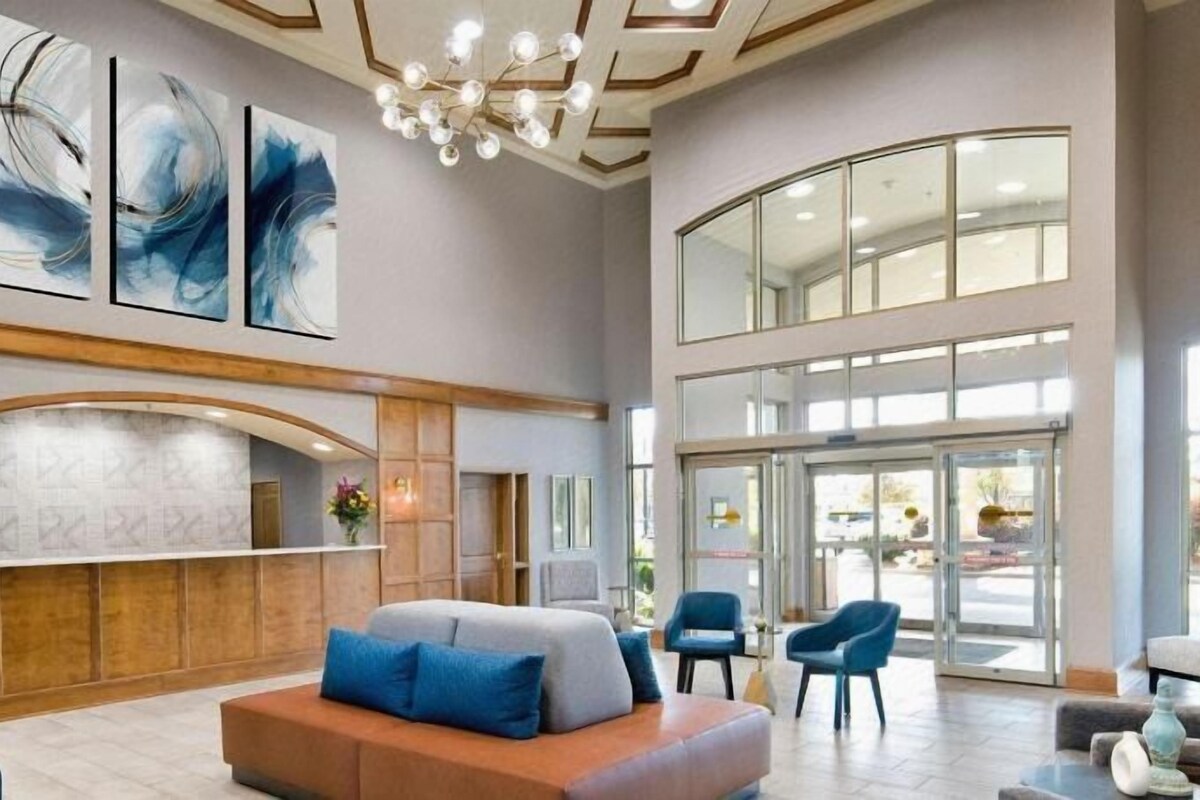 A spacious lobby with a reception desk, seating area, and large windows.