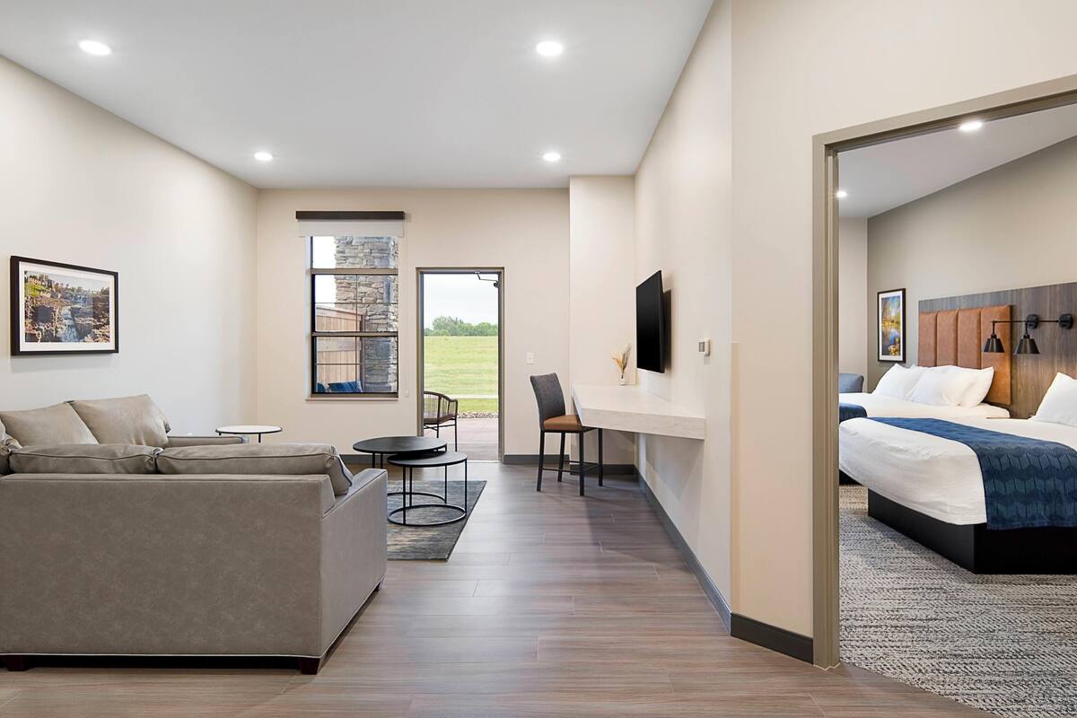 Une chambre d’hôtel moderne équipée d’un canapé, d’un bureau, d’un lit et d’une télévision.