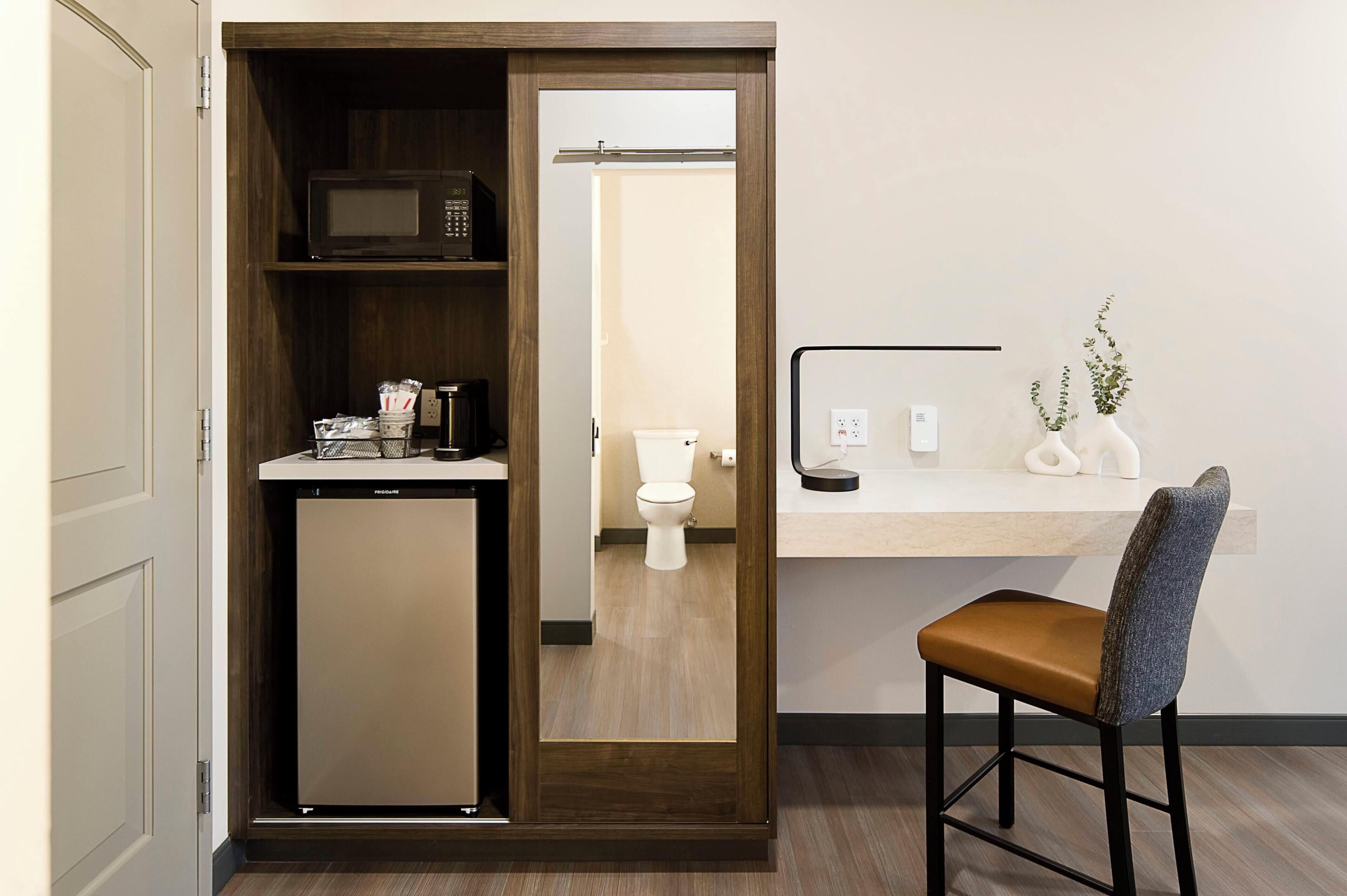 A compact kitchenette with a microwave, a small refrigerator, and a coffee maker.