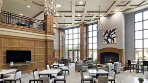 A spacious lobby with multiple seating areas, a fireplace, and large windows. - Clubhouse Hotel Suites Sioux Falls (Sioux Falls)