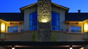 A stone pillar with a fire pit in the center, surrounded by blue chairs. - Clubhouse Hotel Suites Sioux Falls (Sioux Falls)