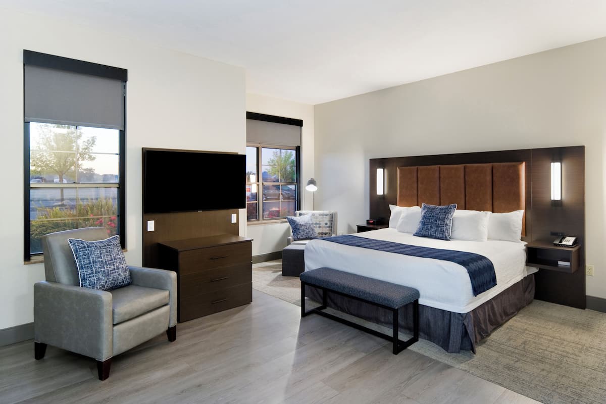 Une chambre d’hôtel moderne équipée d’un grand lit, d’un téléviseur à écran plat, d’un bureau et d’une chaise.