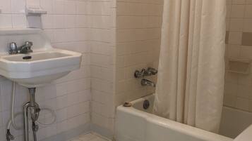 Un baño con lavamanos, inodoro y bañera blancos.