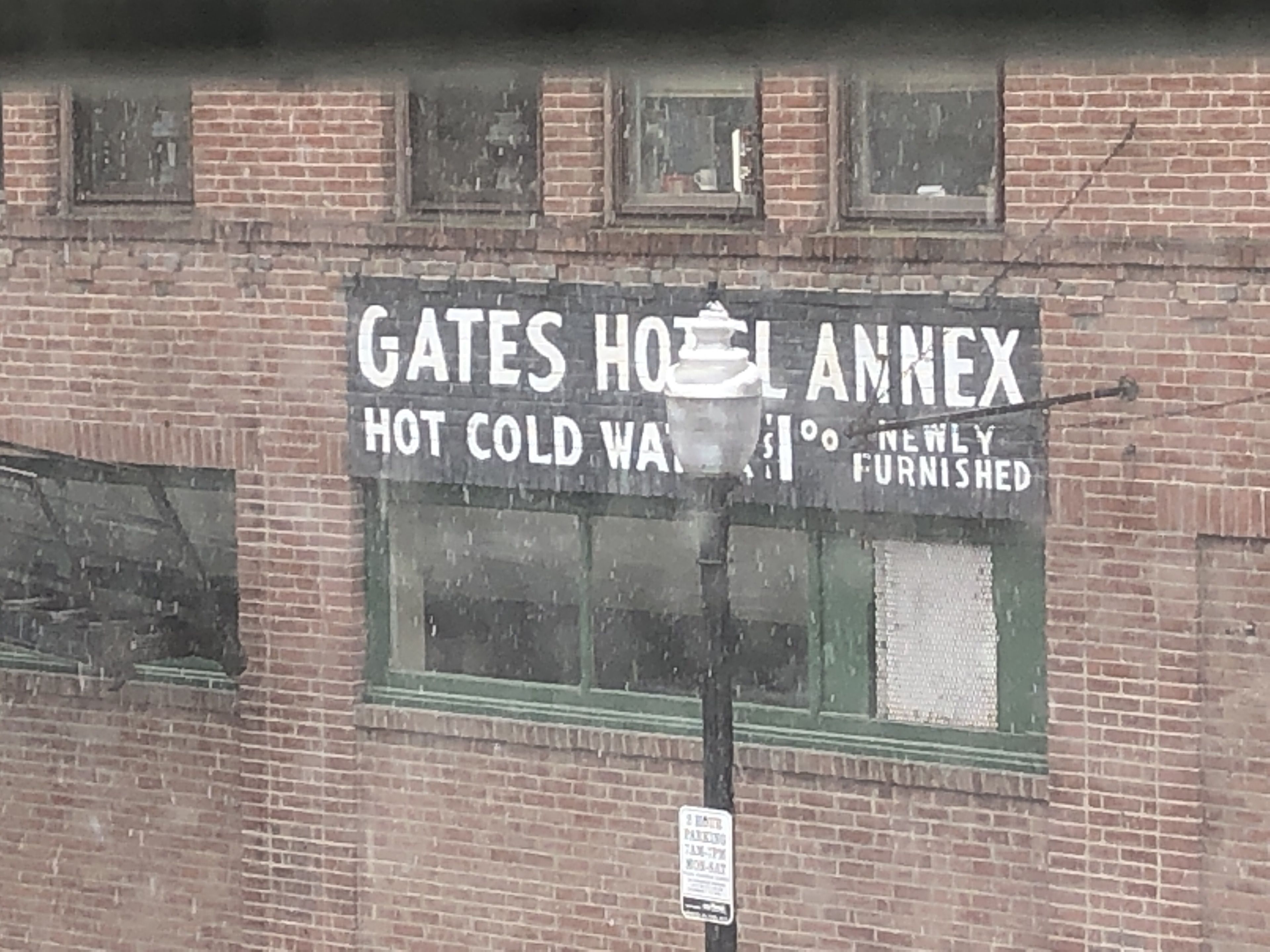 Une enseigne indiquant l’annexe de l’hôtel Gates, où l’on propose de l’eau chaude et froide, ainsi que des chambres récemment rénovées.