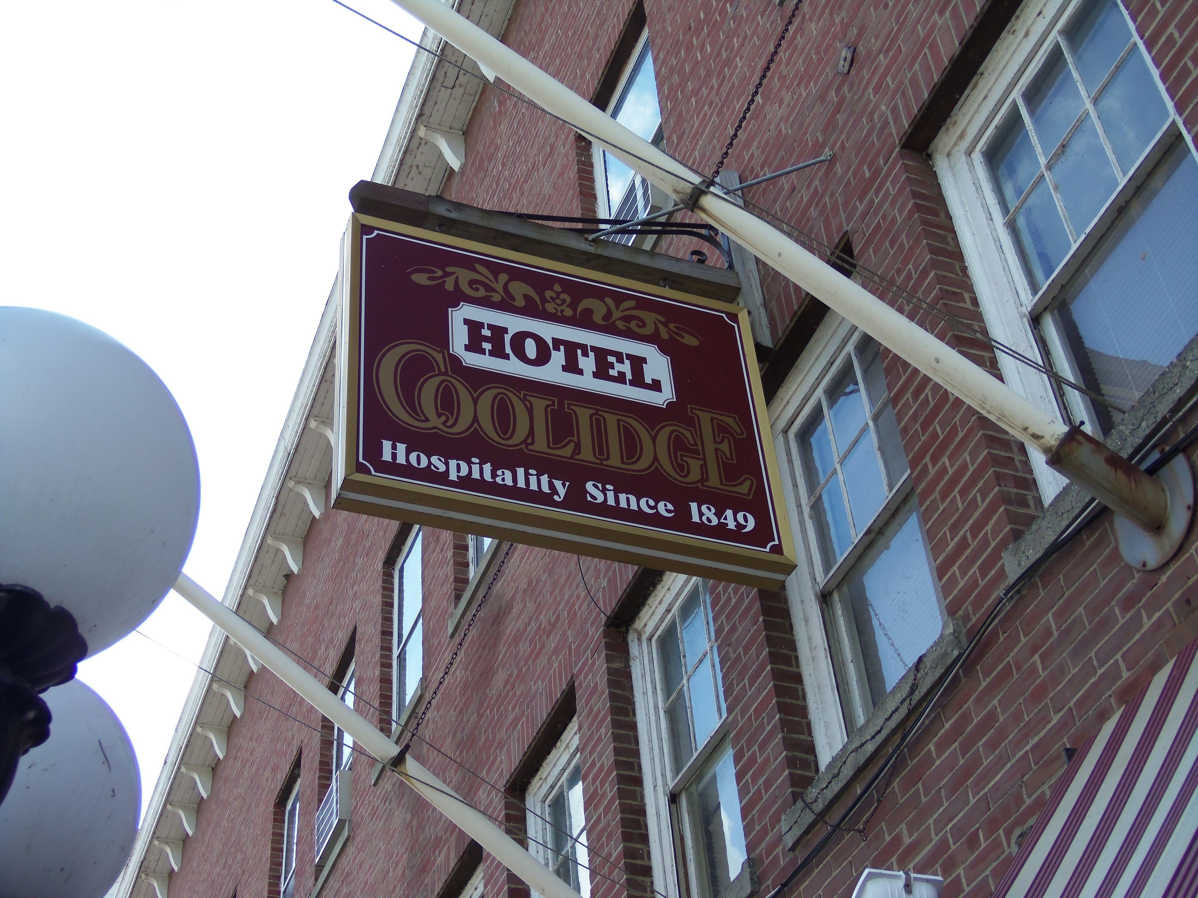 Une enseigne d’hôtel portant le nom « Coolidge » et l’inscription « Depuis 1849, nous vous accueillons avec plaisir ».
