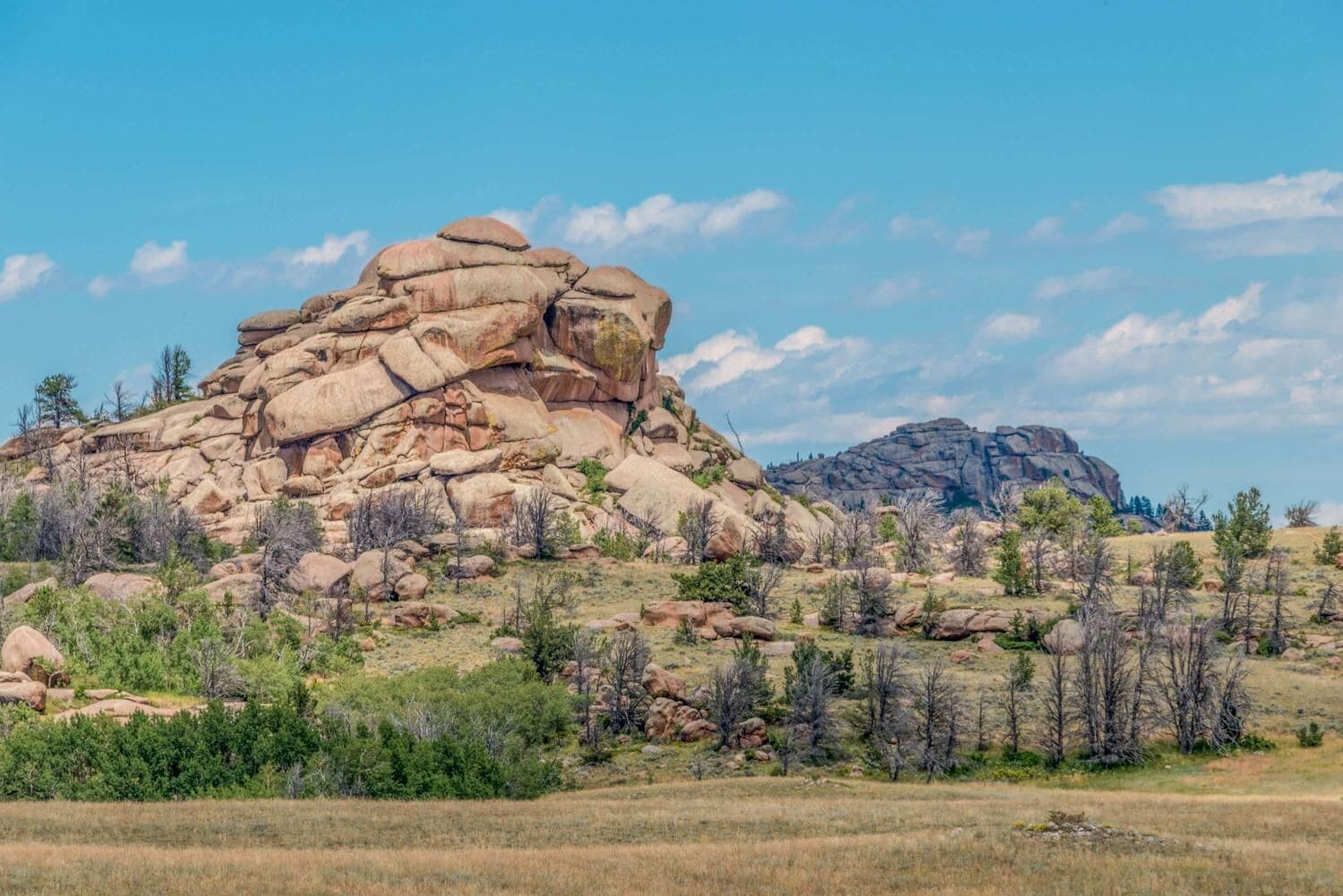 A rugged mountain landscape with large rock formations and sparse vegetation.