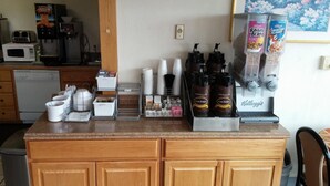 Una encimera de cocina con una cafetera, una licuadora y varios utensilios de cocina.