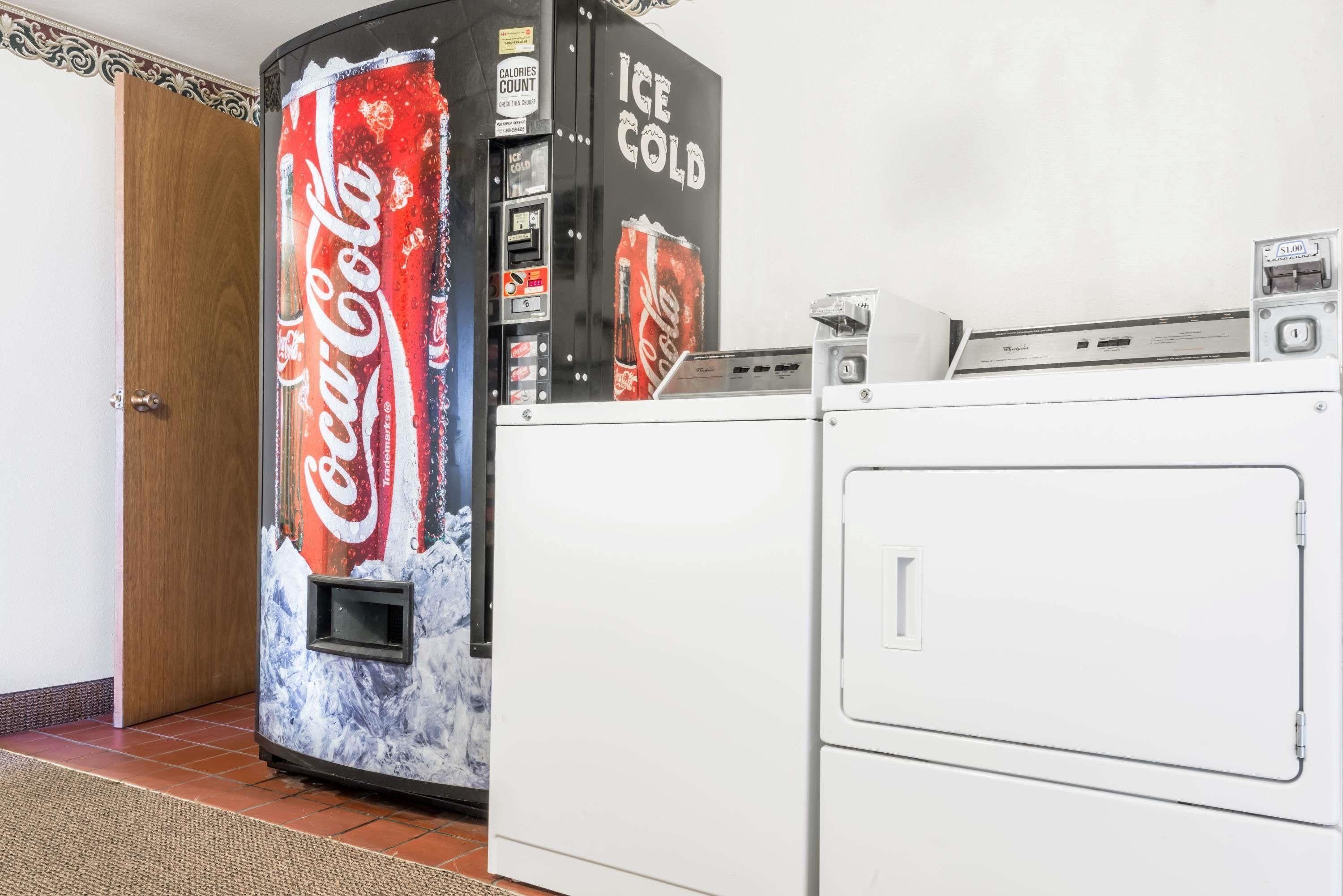 A vending machine with a Coca-Cola design, a coin slot, and an ice dispenser.
