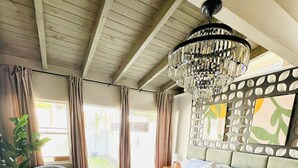 A bedroom with a large bed, a chandelier, a potted plant, and a view of the outdoors. - A Place In The Sun - Adults Only (Palm Springs)