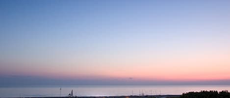 Vista costera con un edificio y un puerto deportivo.