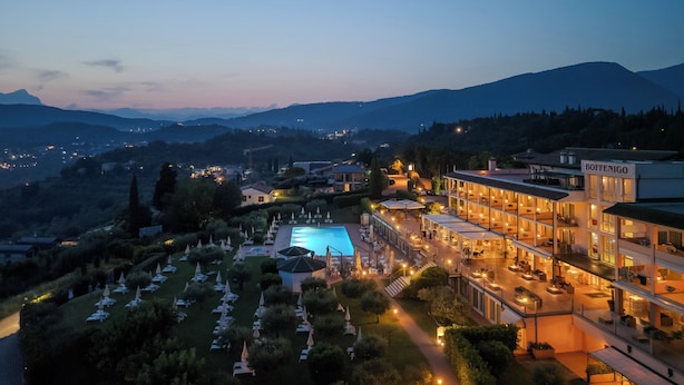 Un hotel con piscina, mobiliario exterior y vistas a la montaña.