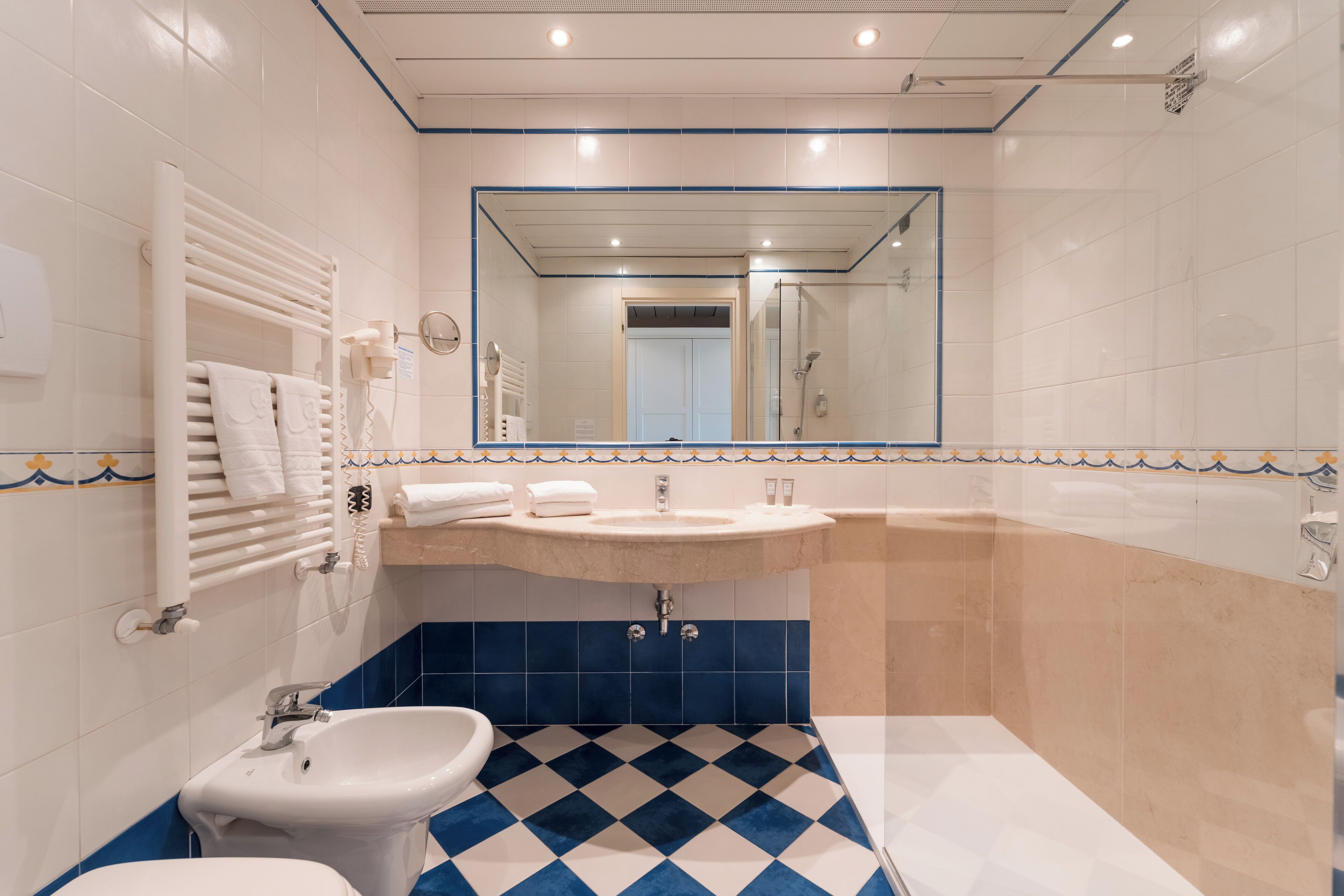 Une salle de bain avec un lavabo, un bidet et un miroir.