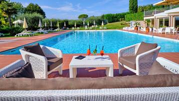 Un área junto a la piscina con sillones de descanso.
