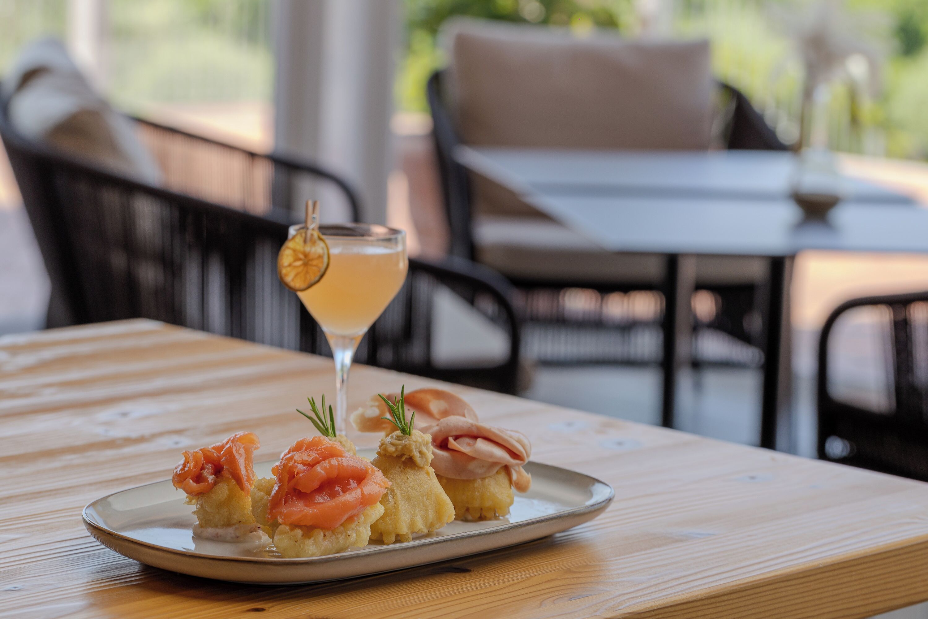 A wooden table with a plate of food and a drink.