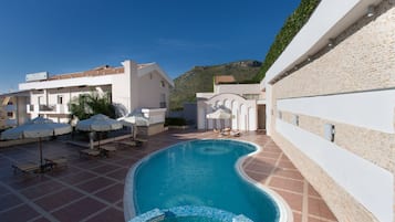 Alberca al aire libre por temporada y sombrillas en la alberca