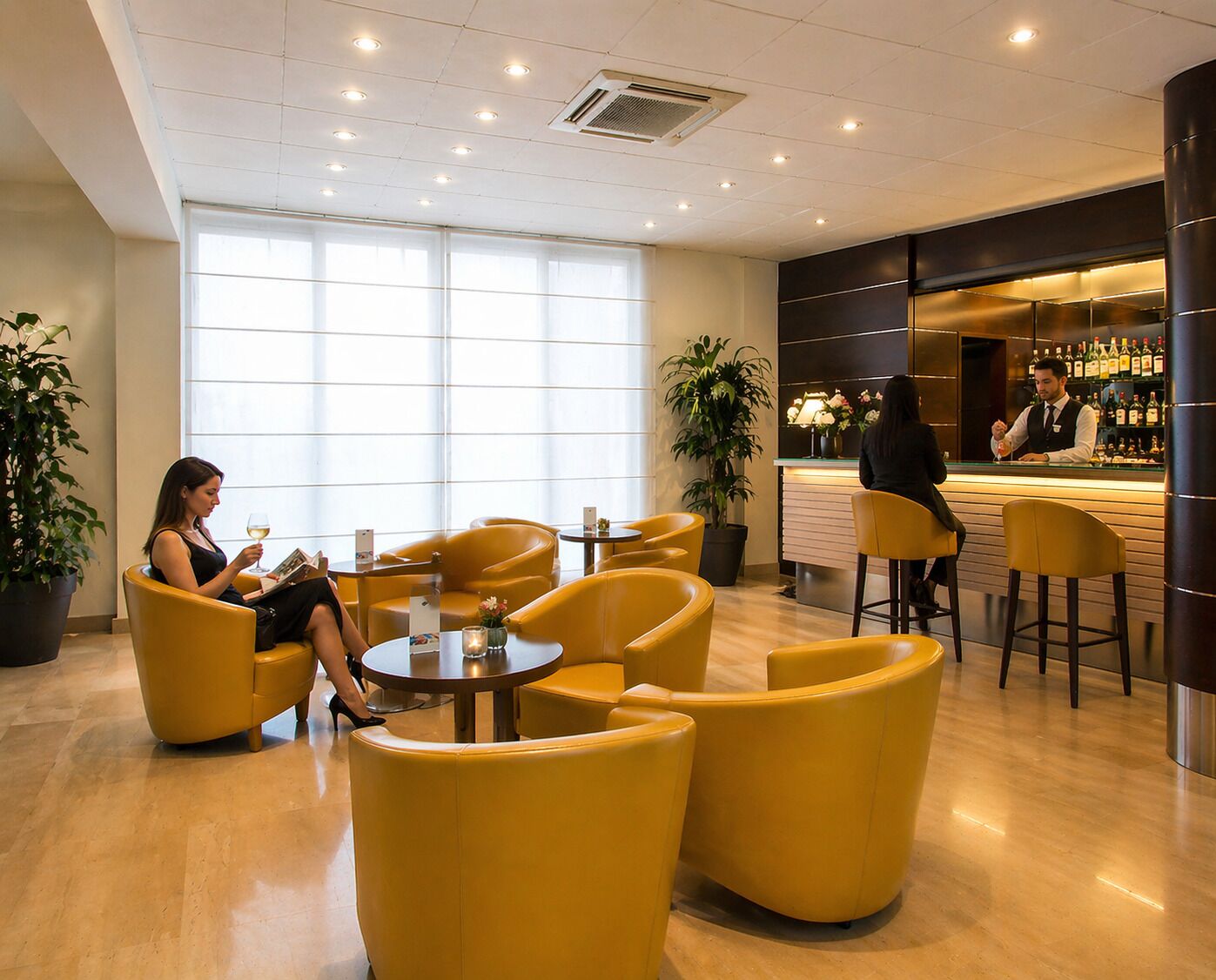 A modern lounge area with yellow seating, a bar with a bartender, and large windows allowing natural light.