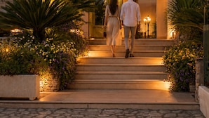 The entrance to Virgilio Grand Hotel with a sign above the entrance, a curved roof, and a pathway leading to the doors. - Virgilio Grand Hotel (Sperlonga)