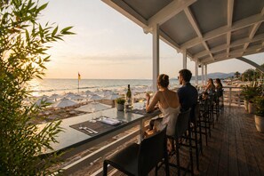 Un restaurante frente al mar con terraza y vistas a la playa y al océano.