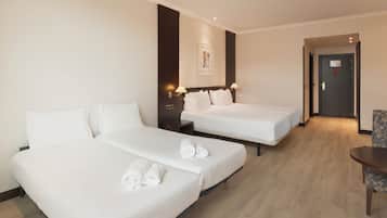 Una habitación de hotel con dos camas individuales, una mesita pequeña y una silla.