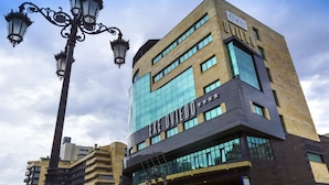 Un edificio moderno con fachada de vidrio y el nombre "EXE OVIEDO" bien visible.
