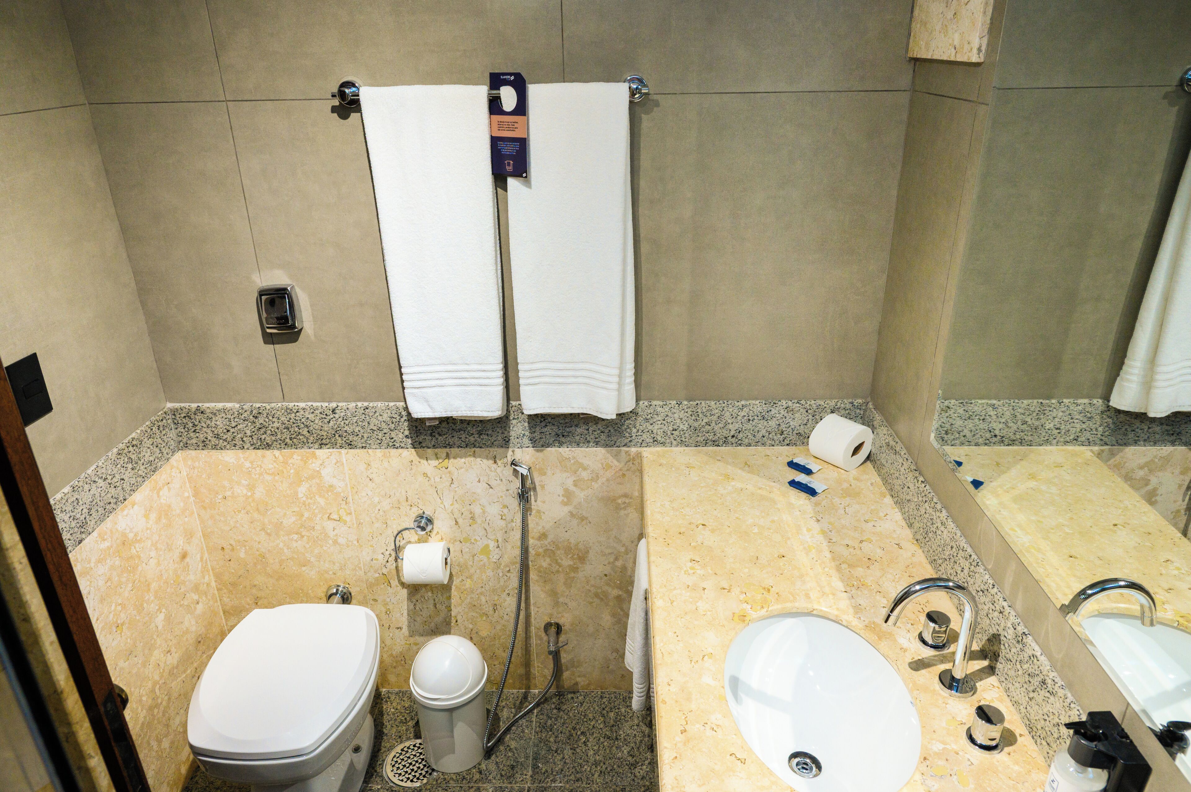 A bathroom with a toilet, bidet, sink, and shower.