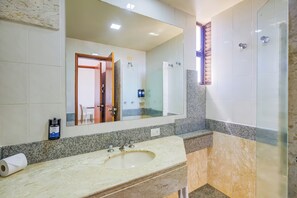 A bathroom with a marble sink, a large mirror, a shower, and a towel rack. - SLAVIERO Londrina (Londrina)