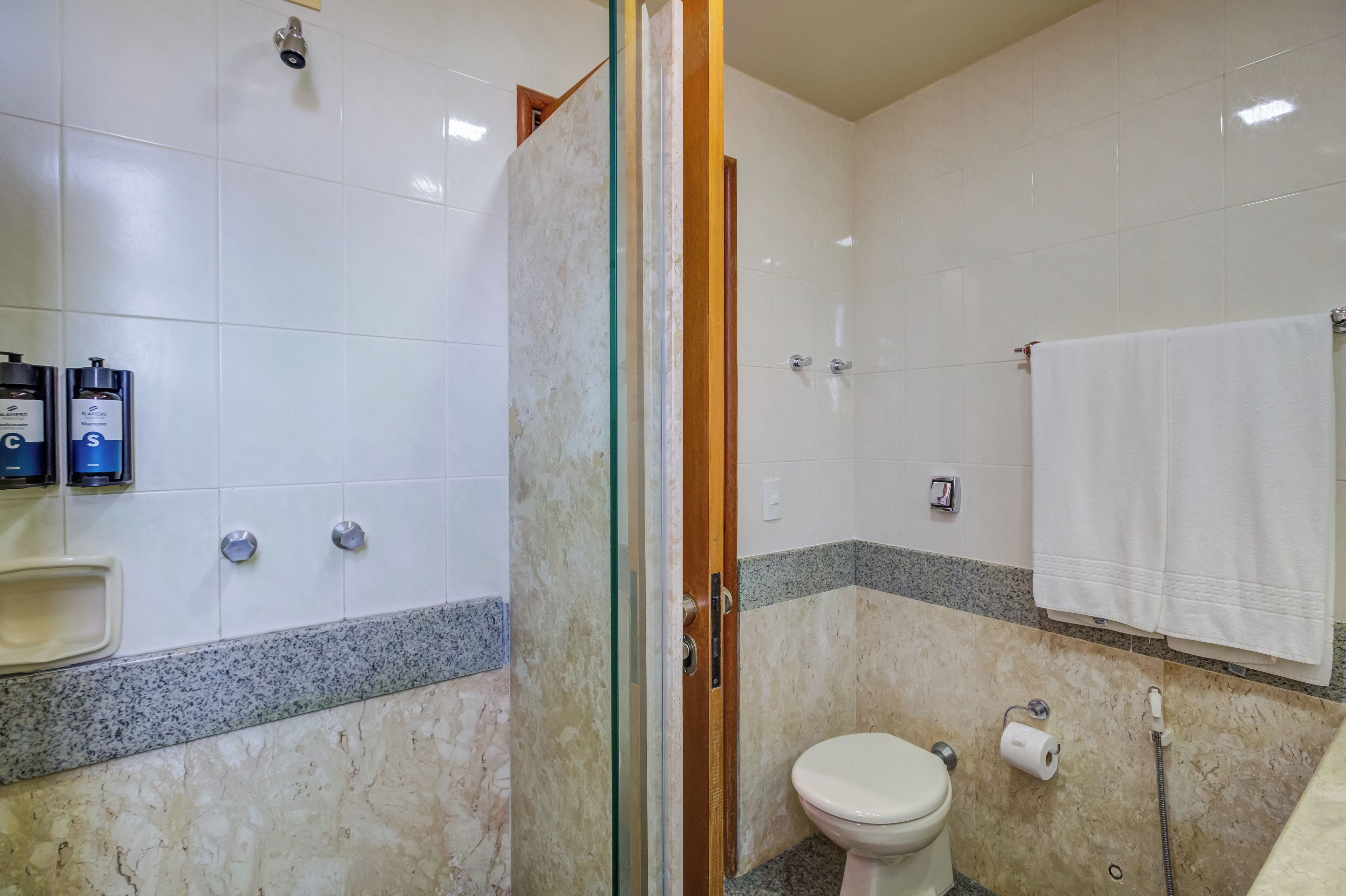 Een badkamer met toilet, douche en wastafel.