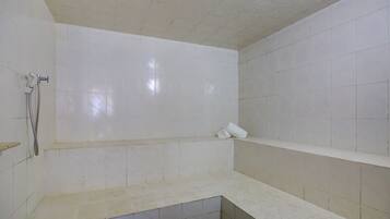 Enjoy a refreshing shower with a seat and handheld showerhead in this bathroom.