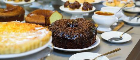 Una mesa de buffet con diversos postres, incluyendo pasteles y dulces.