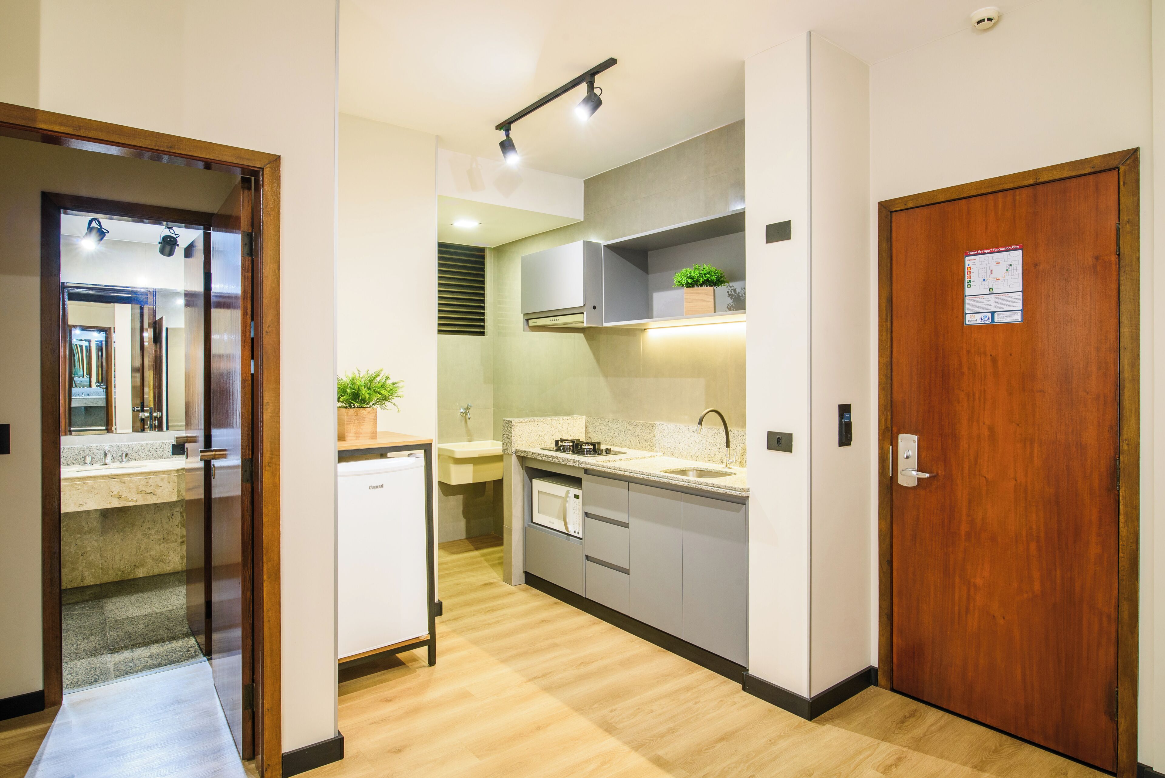 Une cuisine moderne équipée d’un lave-vaisselle, d’un four à micro-ondes et dotée d’une porte en bois.