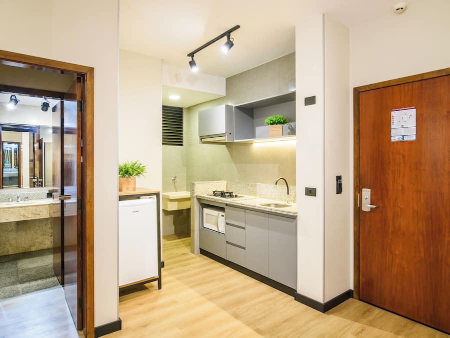 Eine moderne Küche mit Geschirrspüler, Mikrowelle und einer Holztür.