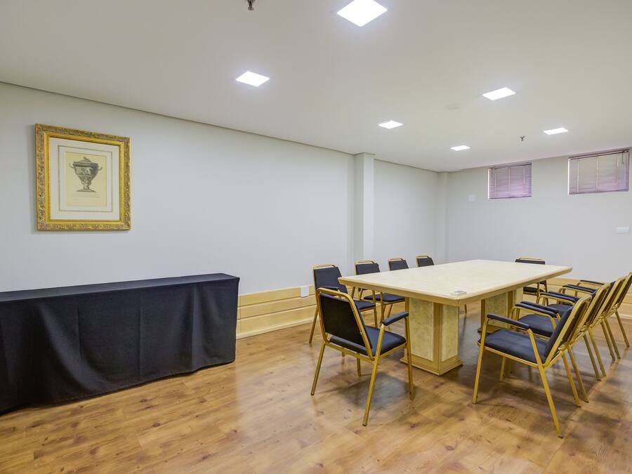 A conference room with a long table, six chairs, and a black tablecloth.