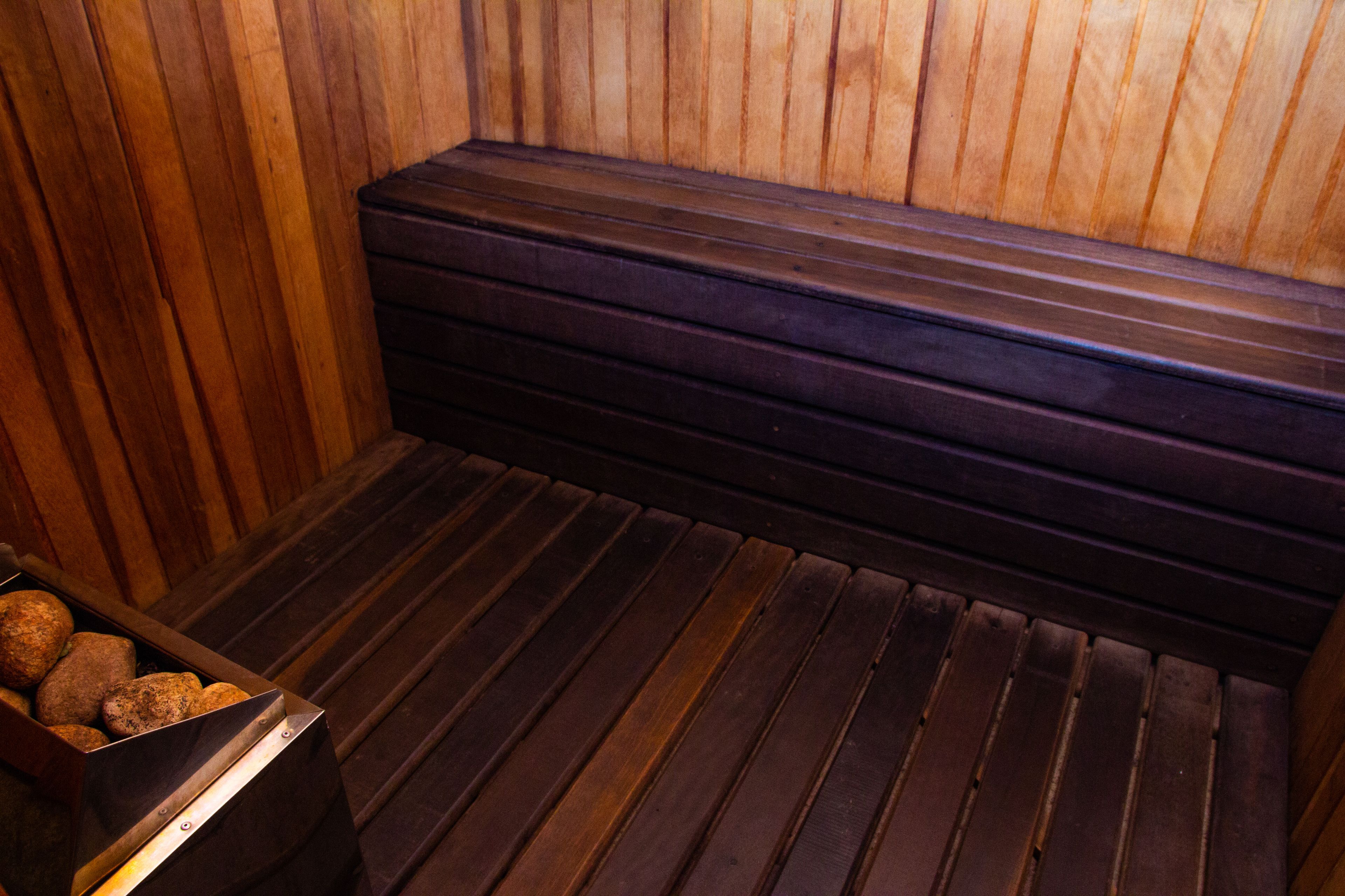 A sauna with wooden benches and a bench with a metal frame.