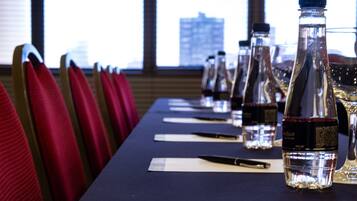 A conference table with water bottles, nameplates, and pens.