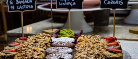 A variety of baked goods displayed on a glass plate with labels indicating different types of muffins and bars.
